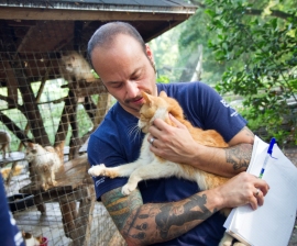 Adam Parascandola holds an orange cat named Velcro rescued by The HSUS